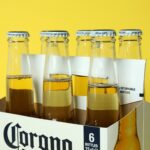 Carton Box with Corona Extra on Yellow Background - Corona Extra beer distributor