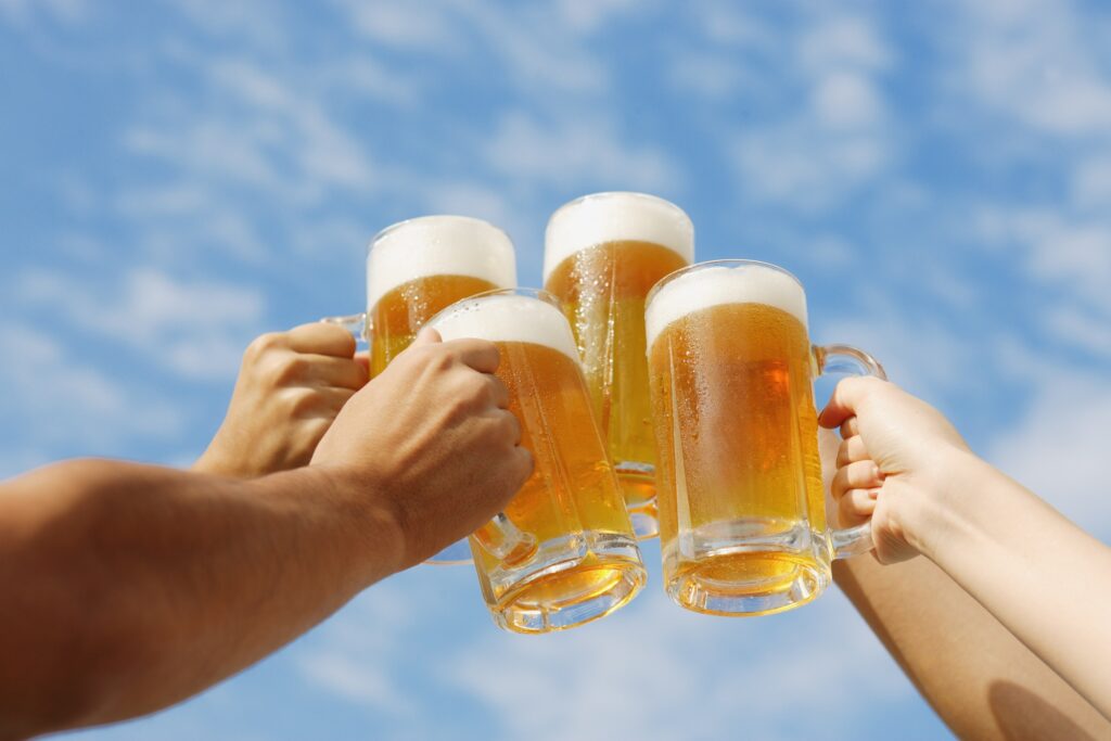Cheers with Corona Beer Mugs Under Clear Blue Sky - Corona Extra beer distributor